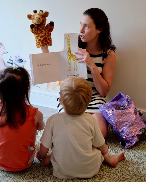 Sarah reading Dear Zoo to a small group. The Giraffe is too tall!