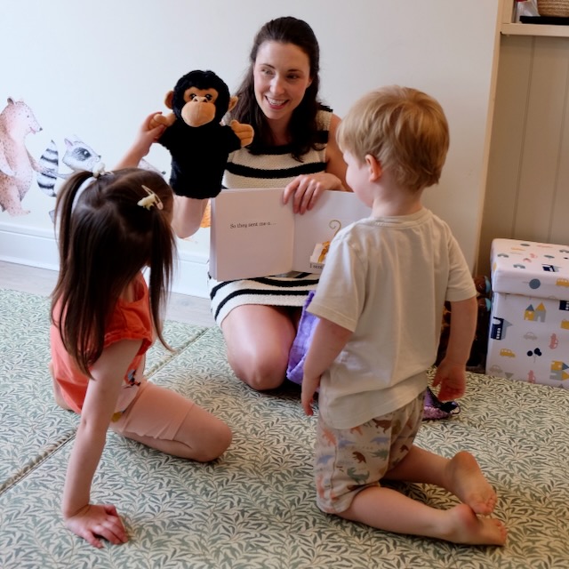 Sarah reading Dear Zoo to a small group showing a monkey